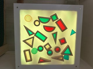 Mesa de luz con mando y figuras traslucidas