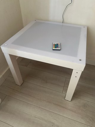 Mesa de luz con mando y figuras traslucidas