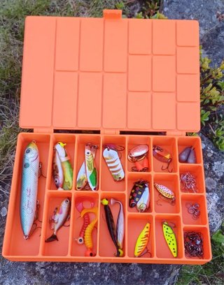 Caja de pesca naranja con señuelos