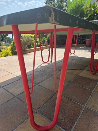 Mesa de ping pong verde con patas rojas