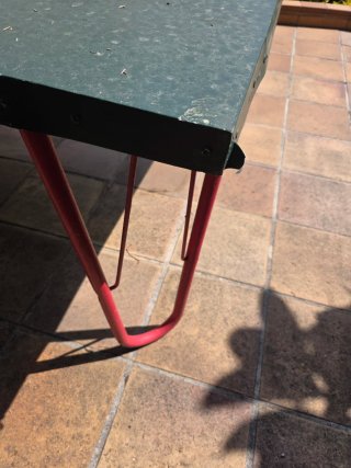 Mesa de ping pong verde con patas rojas