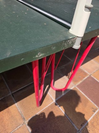 Mesa de ping pong verde con patas rojas