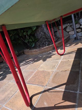 Mesa de ping pong verde con patas rojas