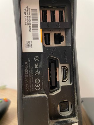 Xbox 360 Slim Negra con un mando