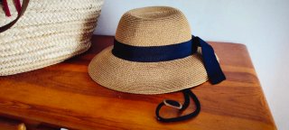 Elegantes sombrero de paja con lazo negro.