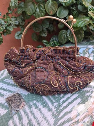Bolso de mano marrón y dorado con adornos