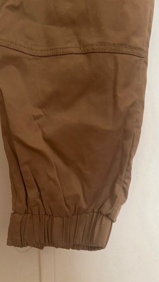 Pantalón beige con cinturón negro