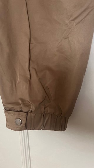 Pantalón beige con cinturón negro