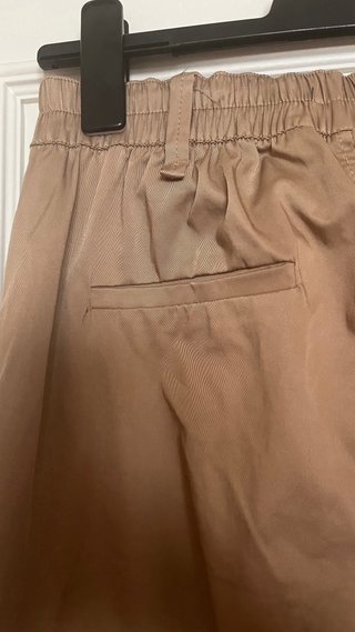 Pantalón beige con cinturón negro