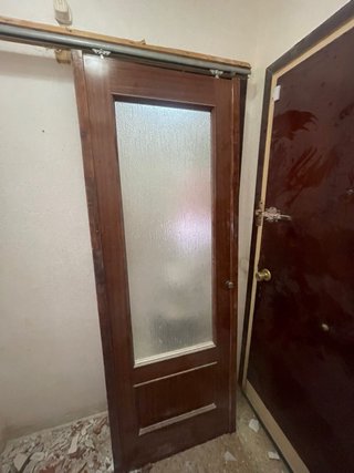 Puerta corredera de madera con cristal y marco