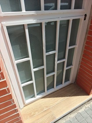 Puerta aluminio con reja y cristal