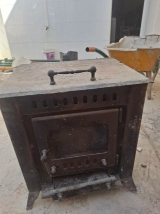 Estufa de hierro rústica con puerta de cristal