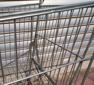 Carrito de compras metálico con mango rojo
