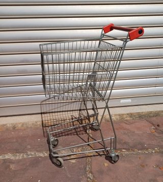 Carrito de compras metálico con mango rojo