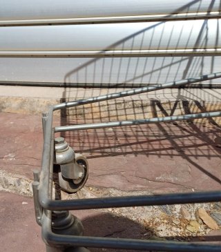 Carrito de compras metálico con mango rojo