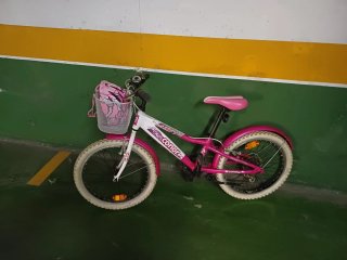 Bicicleta infantil rosa con cesta y casco