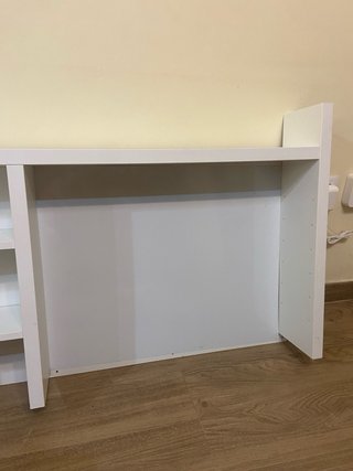 Estantería blanca sobre escritorio.