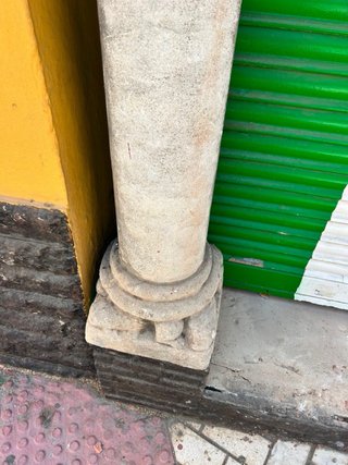 Arco de piedra tallada con dos columnas y capitele