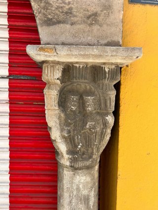 Arco de piedra tallada con dos columnas y capitele