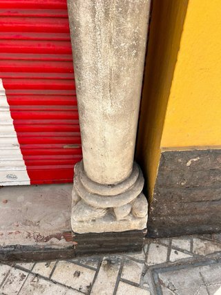 Arco de piedra tallada con dos columnas y capitele