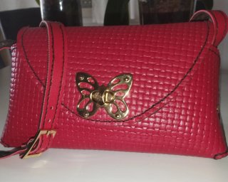 Bolso y cartera de piel con cierre de mariposa.