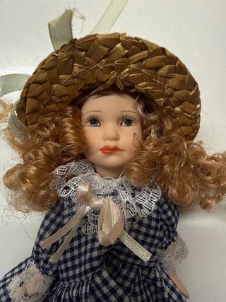 Muñeca de porcelana con vestido a cuadros