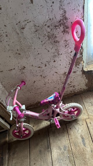Bicicleta infantil rosa con empujador
