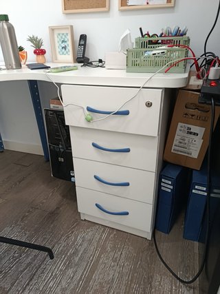 Escritorio blanco grande con patas azules.