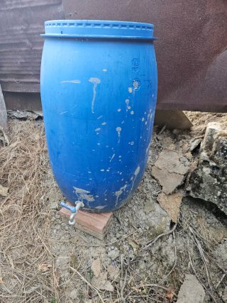Bidón azul para huerta con grifo