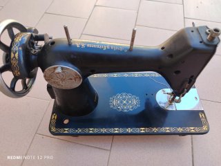 Máquina de coser antigua negra y dorada