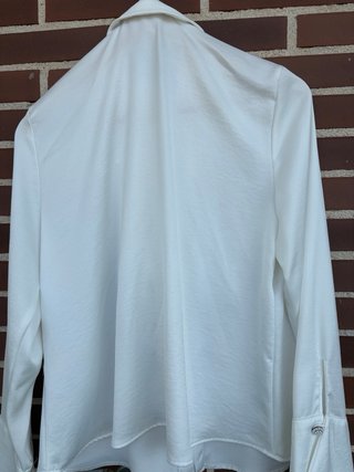 Blusa blanca con volantes y detalle joya