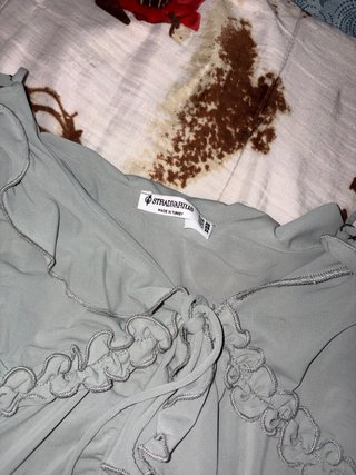 Camiseta azul con volantes y lazada en medio