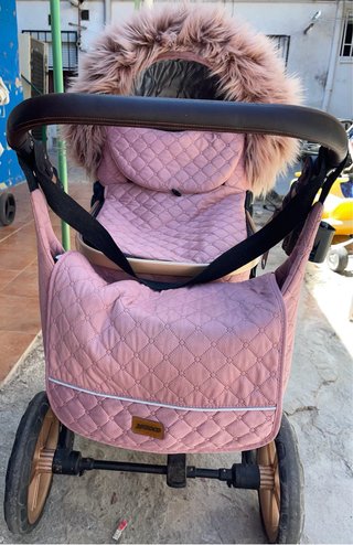 Carro de bebé rosa con capazo y accesorios