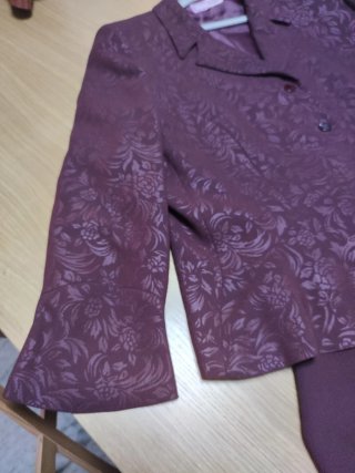 Traje de chaqueta y falda en tono berenjena.