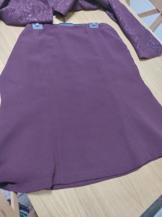 Traje de chaqueta y falda en tono berenjena.