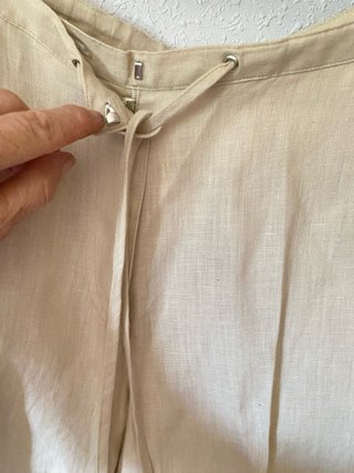 Pantalón de lino beige con bordado rosa