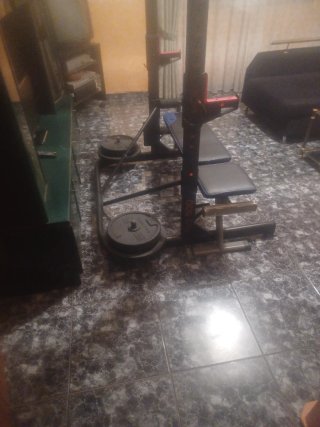 Banco de gimnasio con barras y pesas