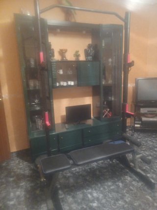 Banco de gimnasio con barras y pesas