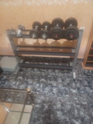 Banco de gimnasio con barras y pesas