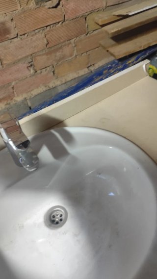 Mueble de baño con lavabo de porcelana y espejo .
