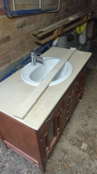 Mueble de baño con lavabo de porcelana y espejo .