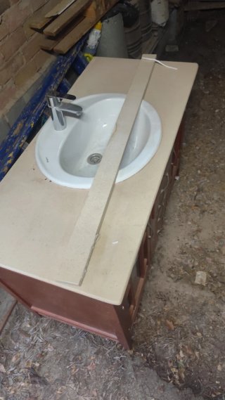 Mueble de baño con lavabo de porcelana y espejo .