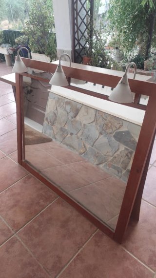 Mueble de baño con lavabo de porcelana y espejo .