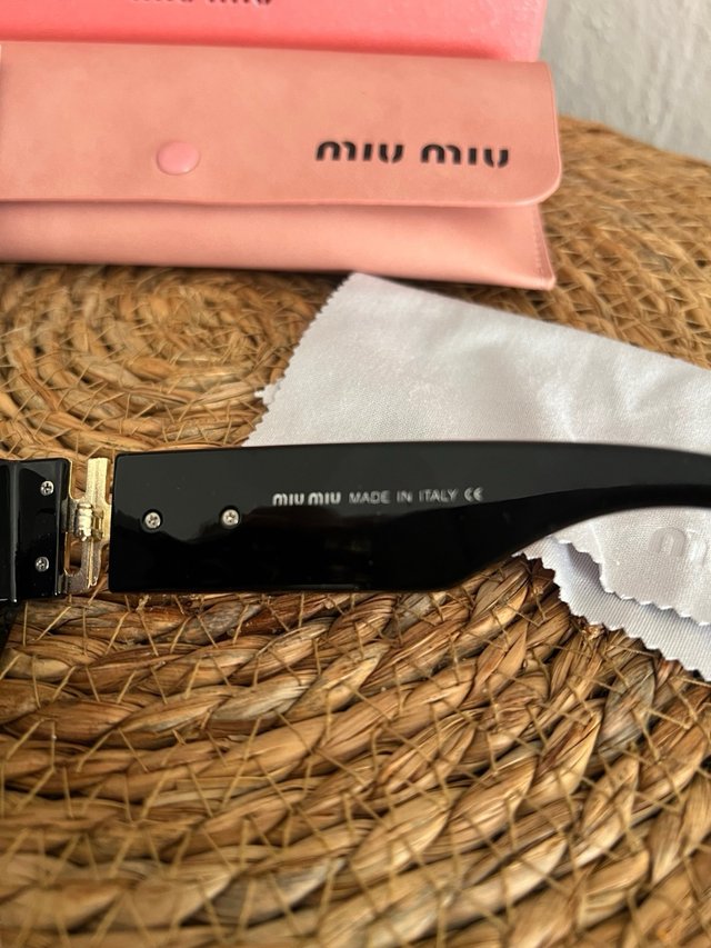 Gafas de sol Miu Miu negras y doradas