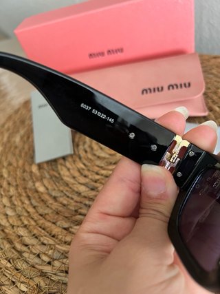 Gafas de sol Miu Miu negras y doradas