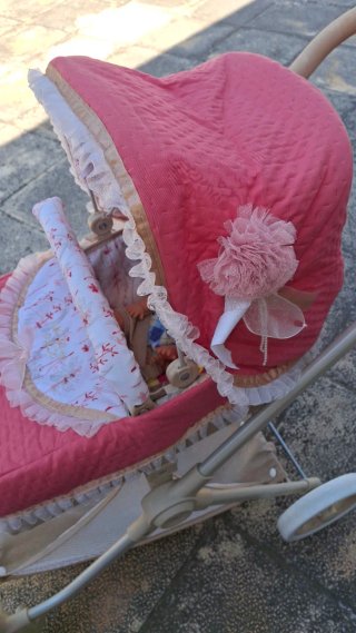 Carro de muñecas rosa con capota