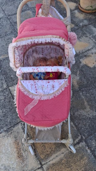 Carro de muñecas rosa con capota