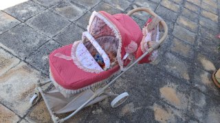 Carro de muñecas rosa con capota