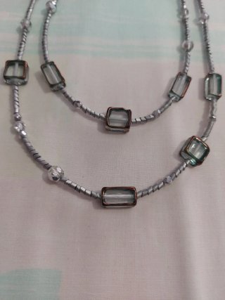 Collar largo plateado.