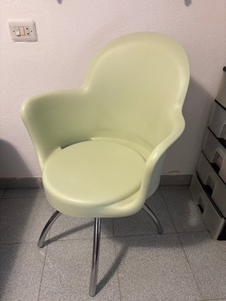 Silla de plástico verde con patas metálicas